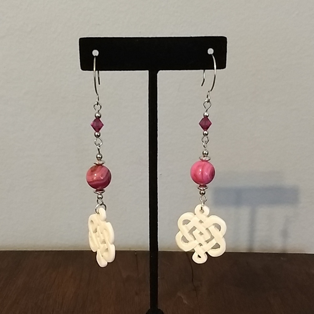 Pink beaded dangle earrings with bone celtic knot